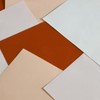 From above of blank paper sheets of different colors scattered on table as abstract background